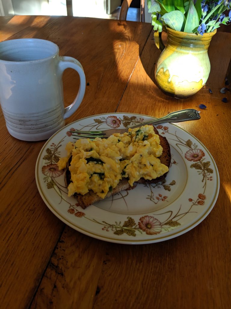 Breakfast with eggs on toast with garden fresh spinach.