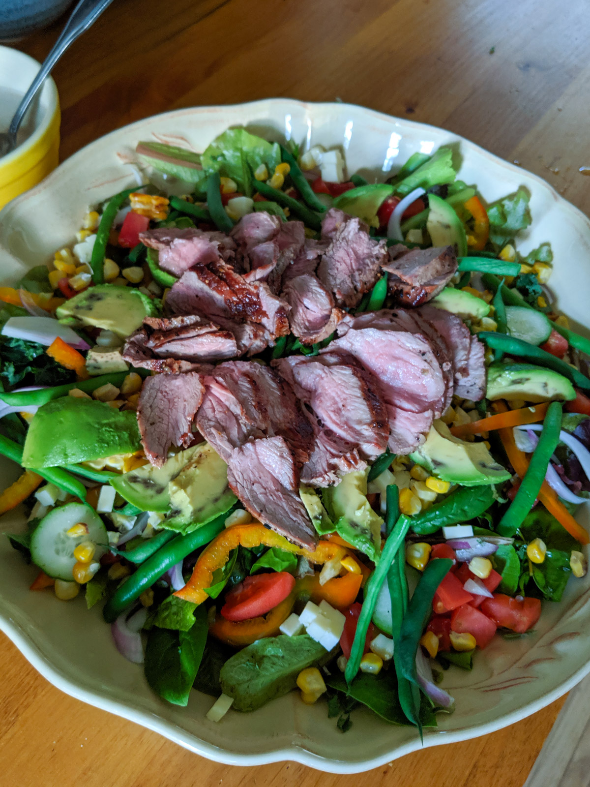 Garden fresh salad topped with sliced steak.