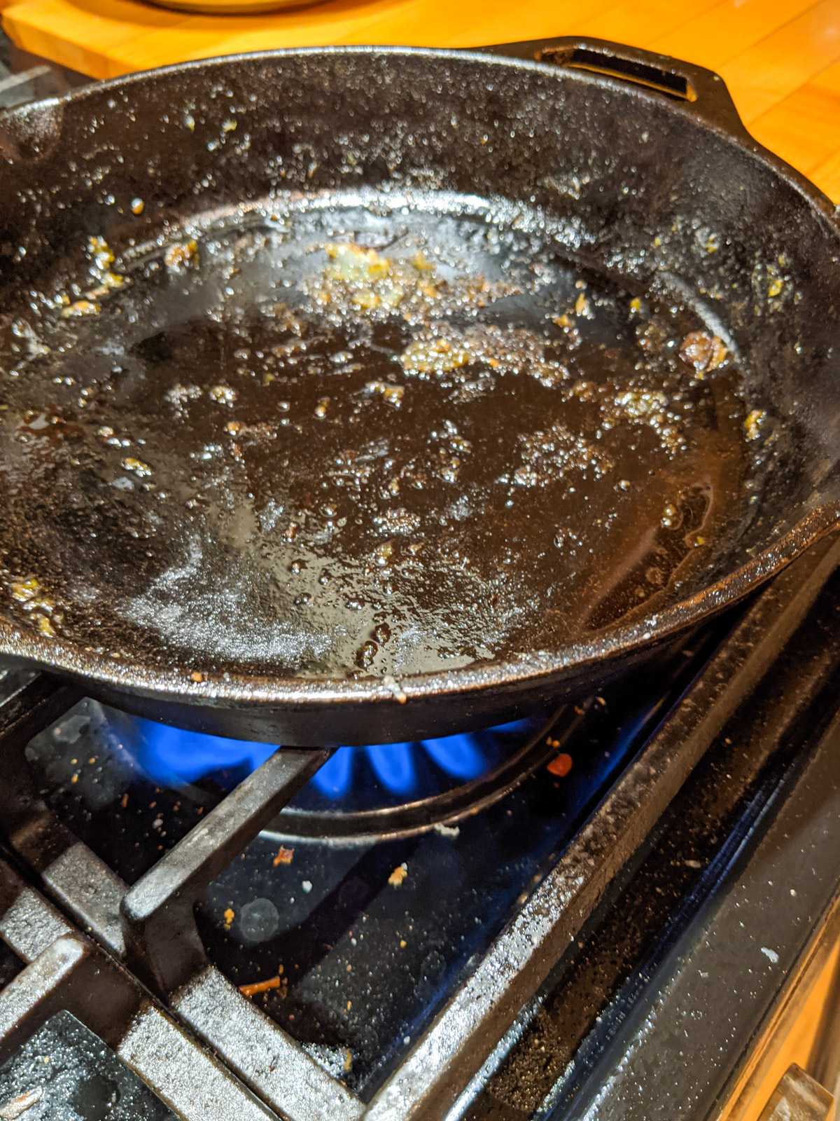 Heating up a dirty cast iron skillet on the stove top in order to deglaze it to clean it.