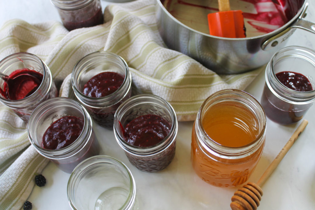 Filling jars of mulberry honey sweetened jam.