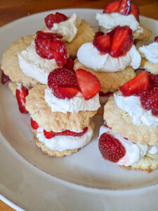 Finished strawberry shortcakes layered with whipped cream and fresh strawberries.