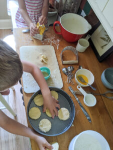 A countertop with kids helping to make strawberry shortcake.
