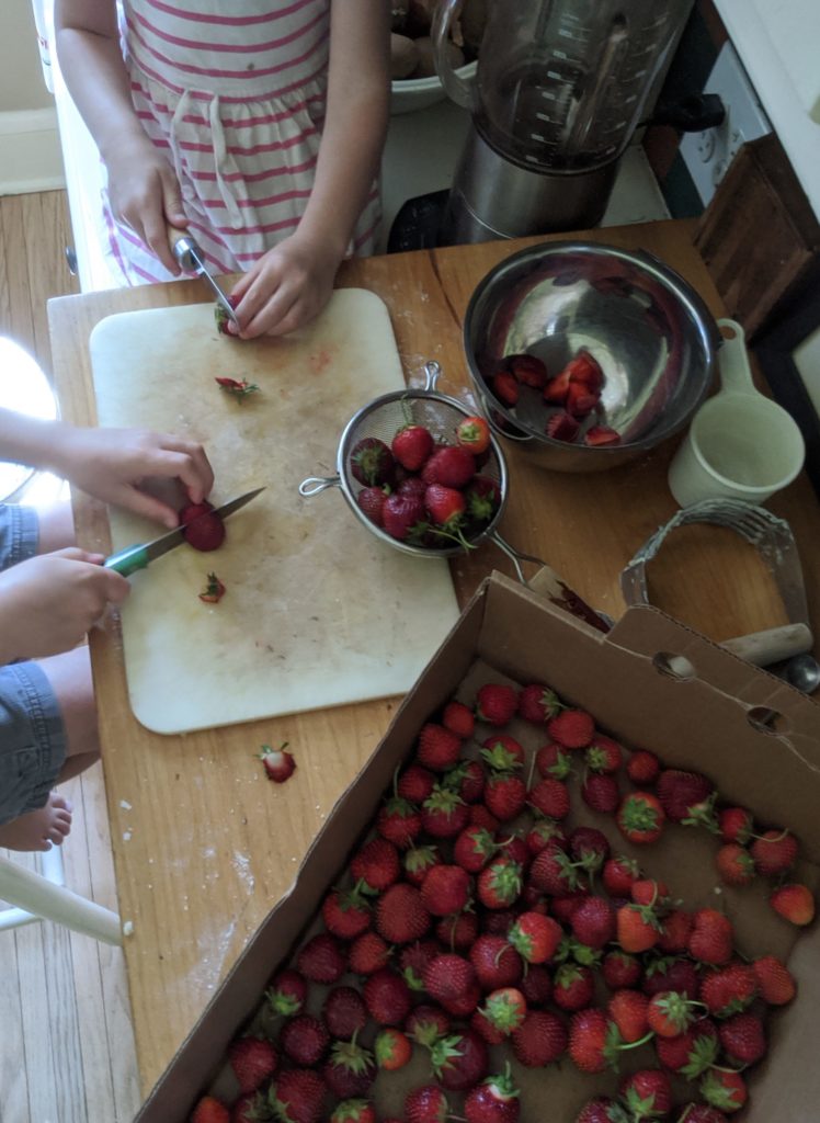 Kids slicing strawberries for short cake