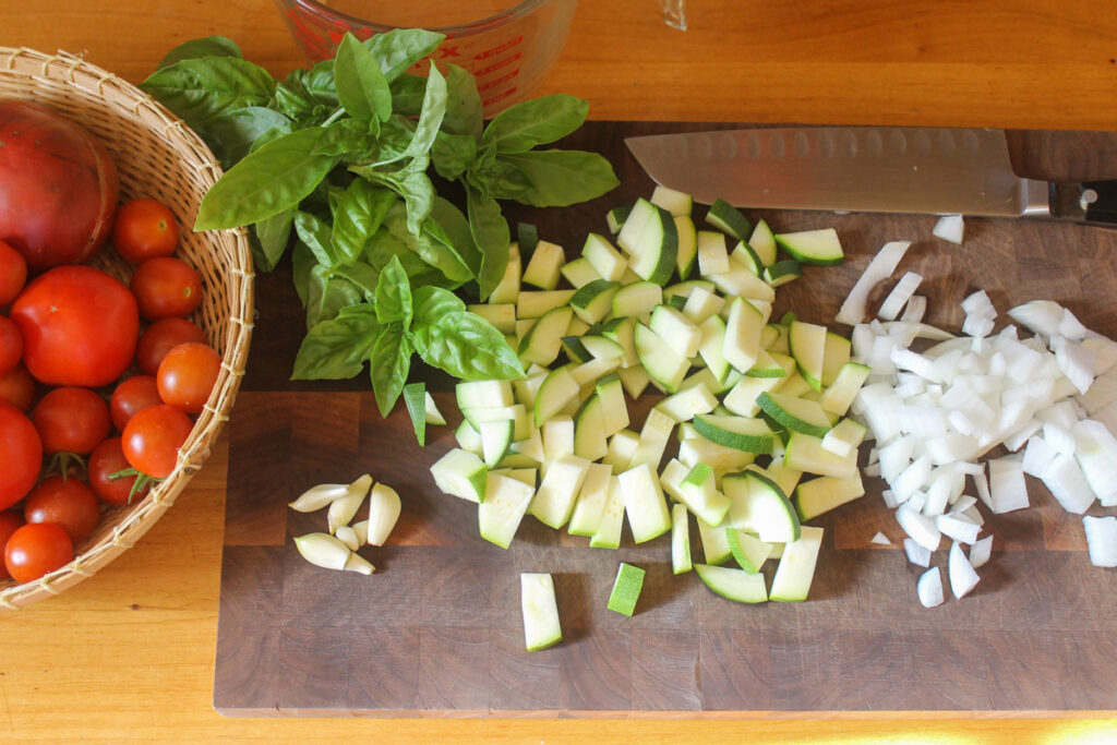 Creamy Tomato Basil Pasta ingredients on a cutting board.