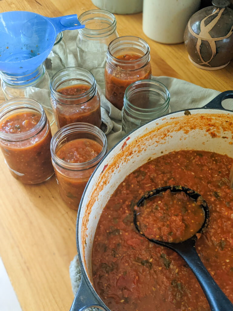 Filling jars of freezer marinara from garden tomatoes.