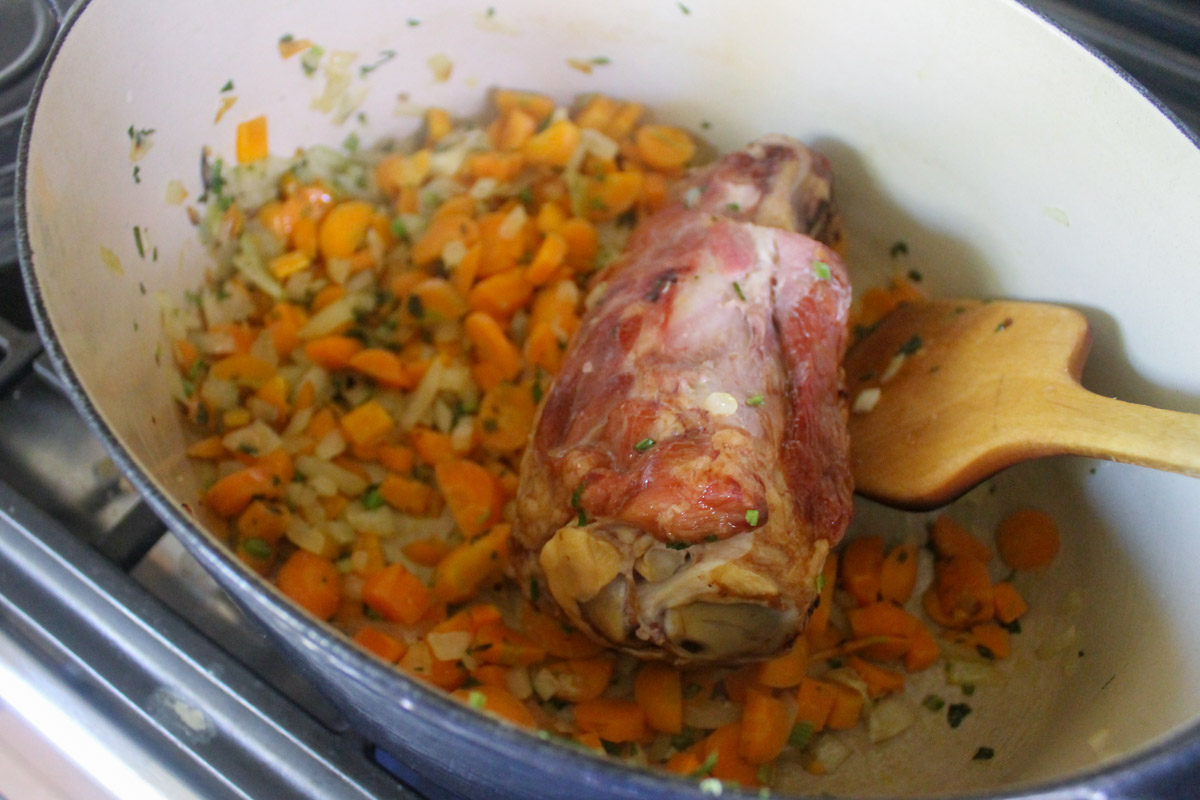 A ham hock sauteing with veggies for split pea soup.