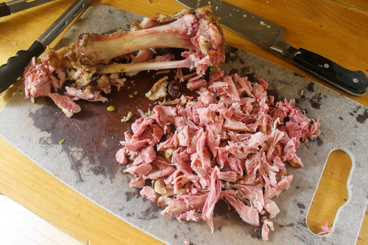 Ham pulled off the bone and shredded on a cutting board.