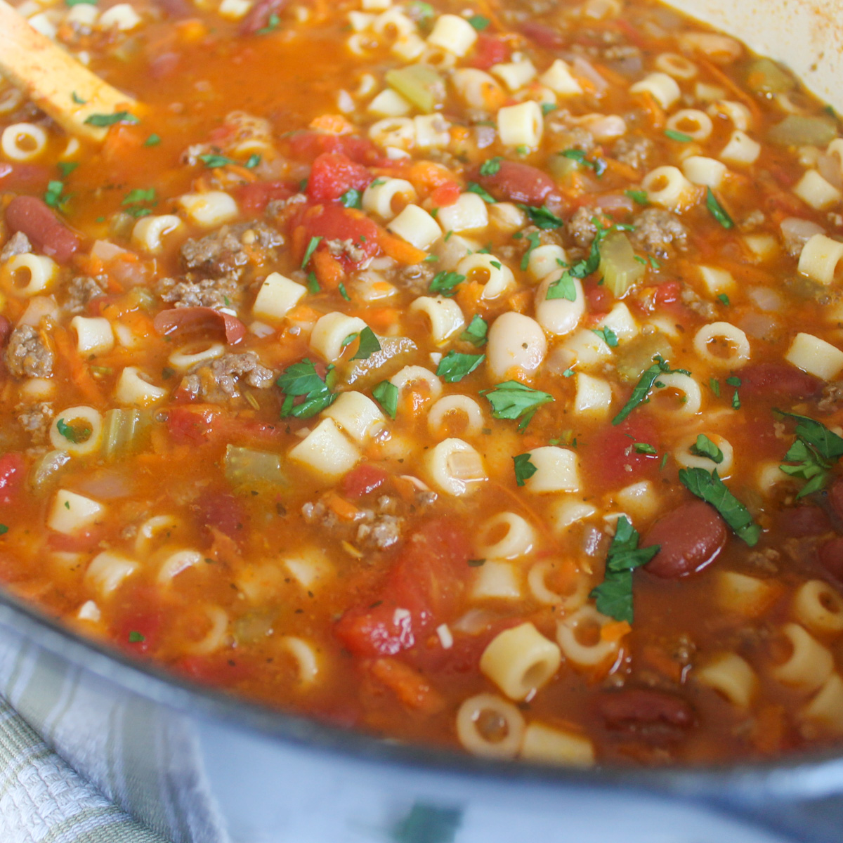 A pot of Pasta Fagioli Soup in a rich red tomato broth with beef, veggies, beans and pasta.