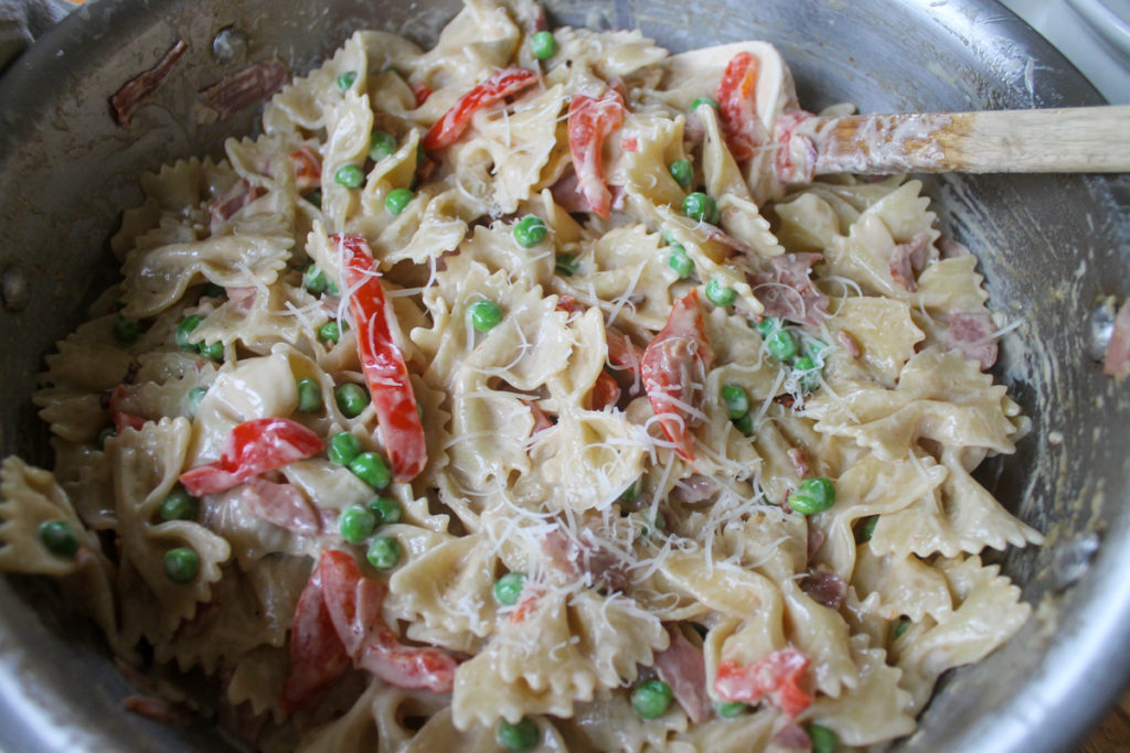 The finished Creamy Farfalle Pasta with Prosciutto and Peas topped with Parmesan cheese.