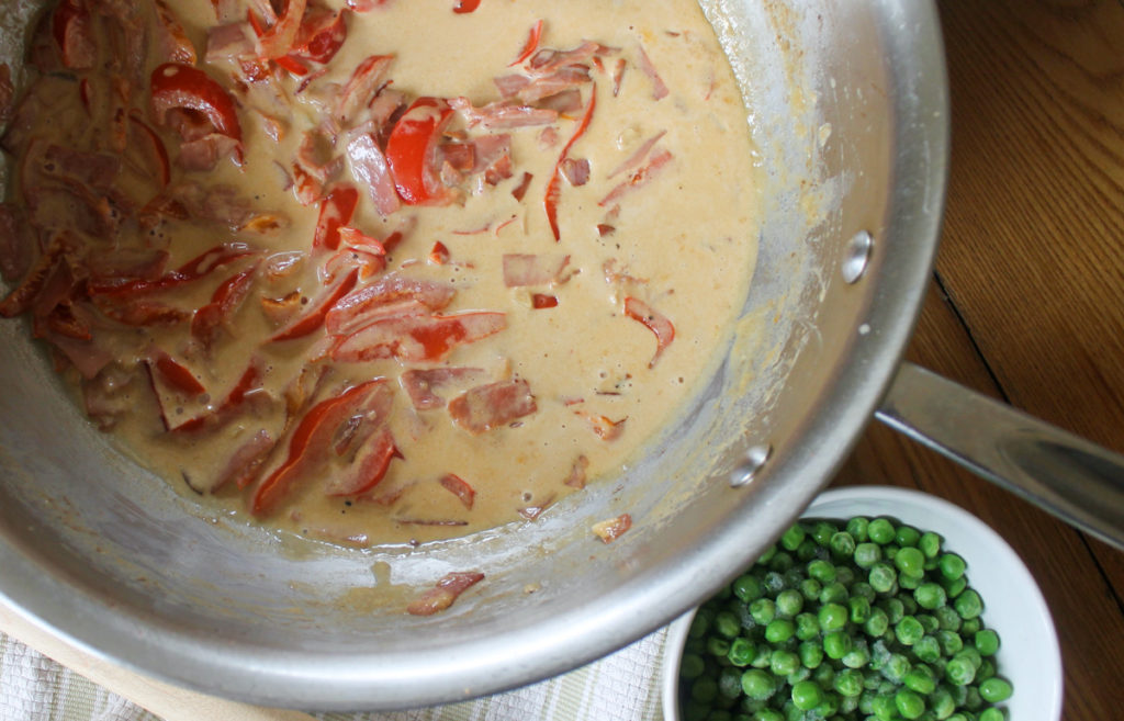 Garlic and cream added to the sauce and simmering to reduce and thicken.