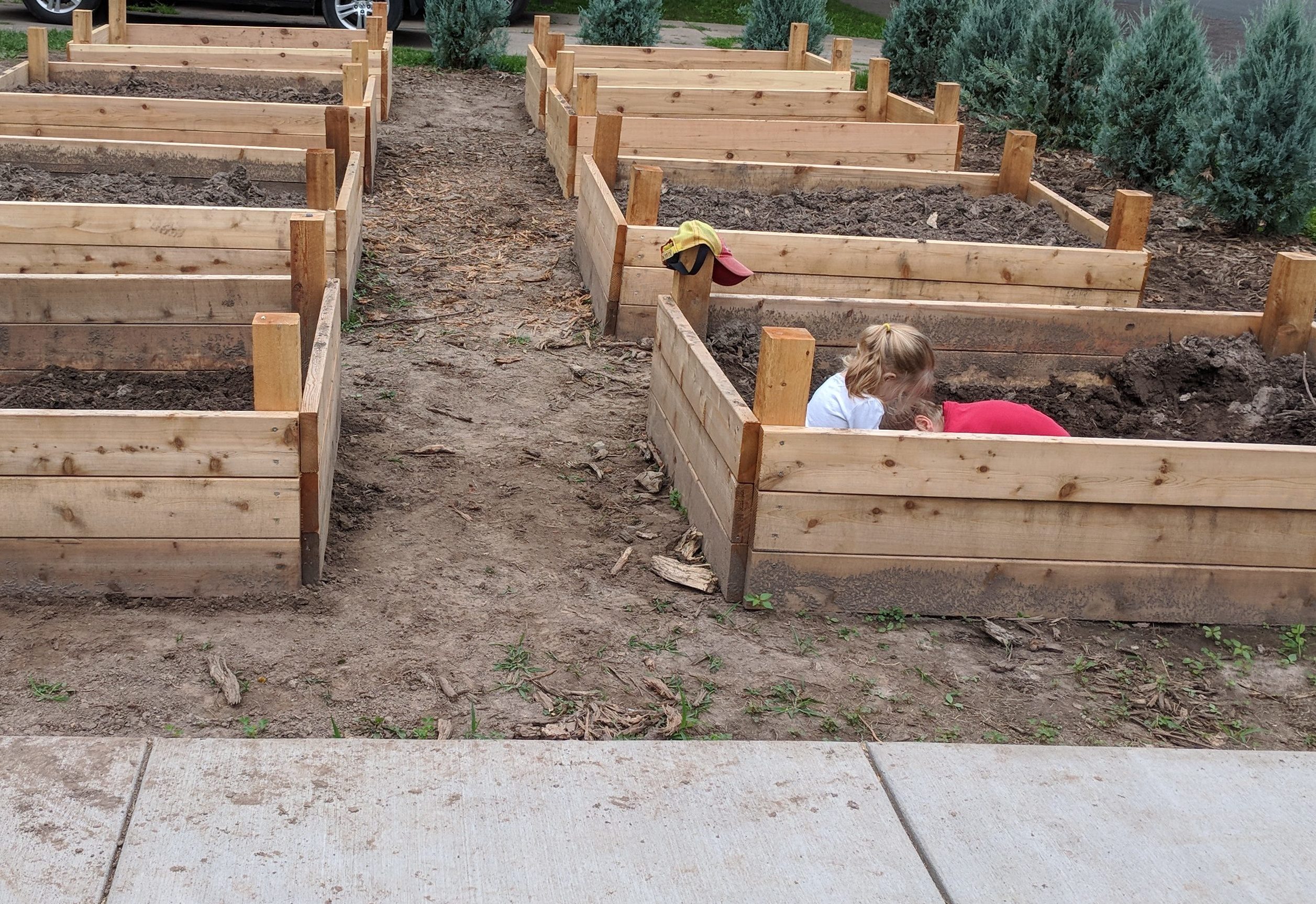 Kids playing in a raised bed garden box.