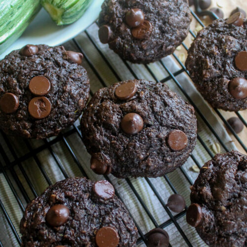 Double Chocolate Zucchini muffins on cooling rack with big chocolate chips on top.