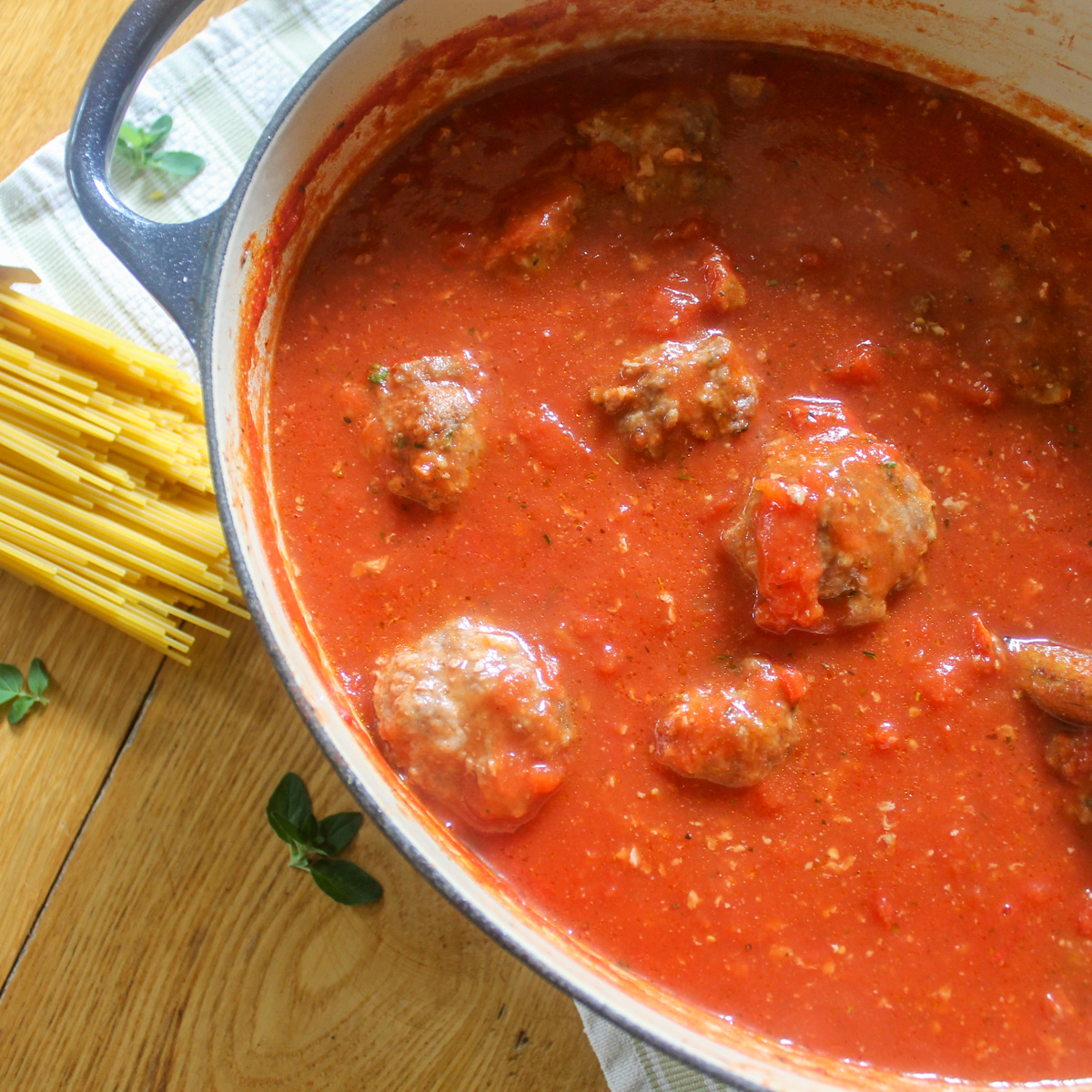 A dutch oven pot of meatballs in tomato sauce.