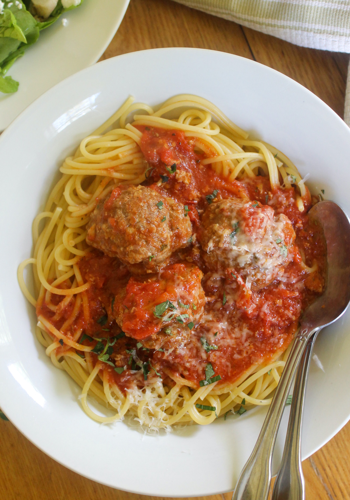 Spaghetti and homemade meatballs with a side salad.