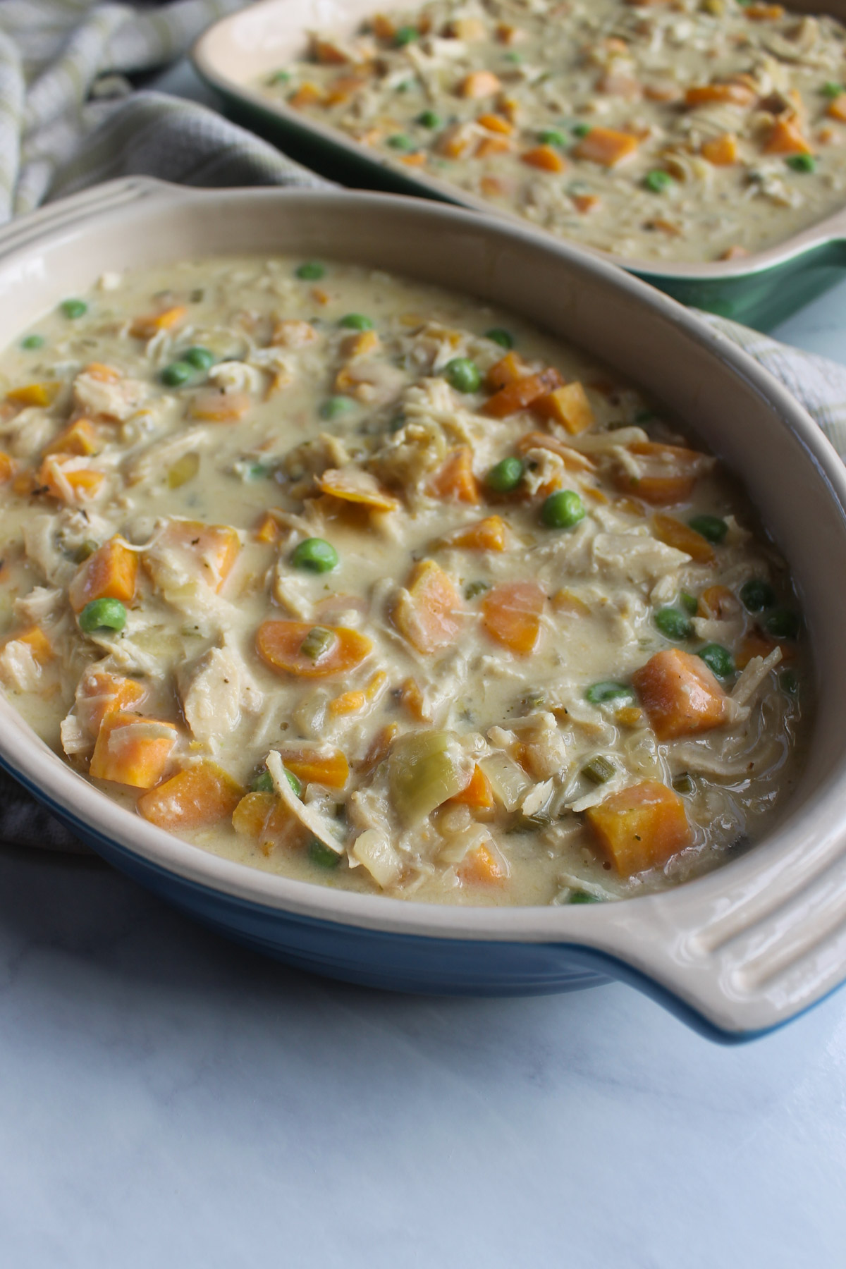 Two smaller casserole dishes with chicken pot pie filling.