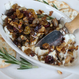 Goat cheese appetizer dip with a small knife for spreading on crackers.