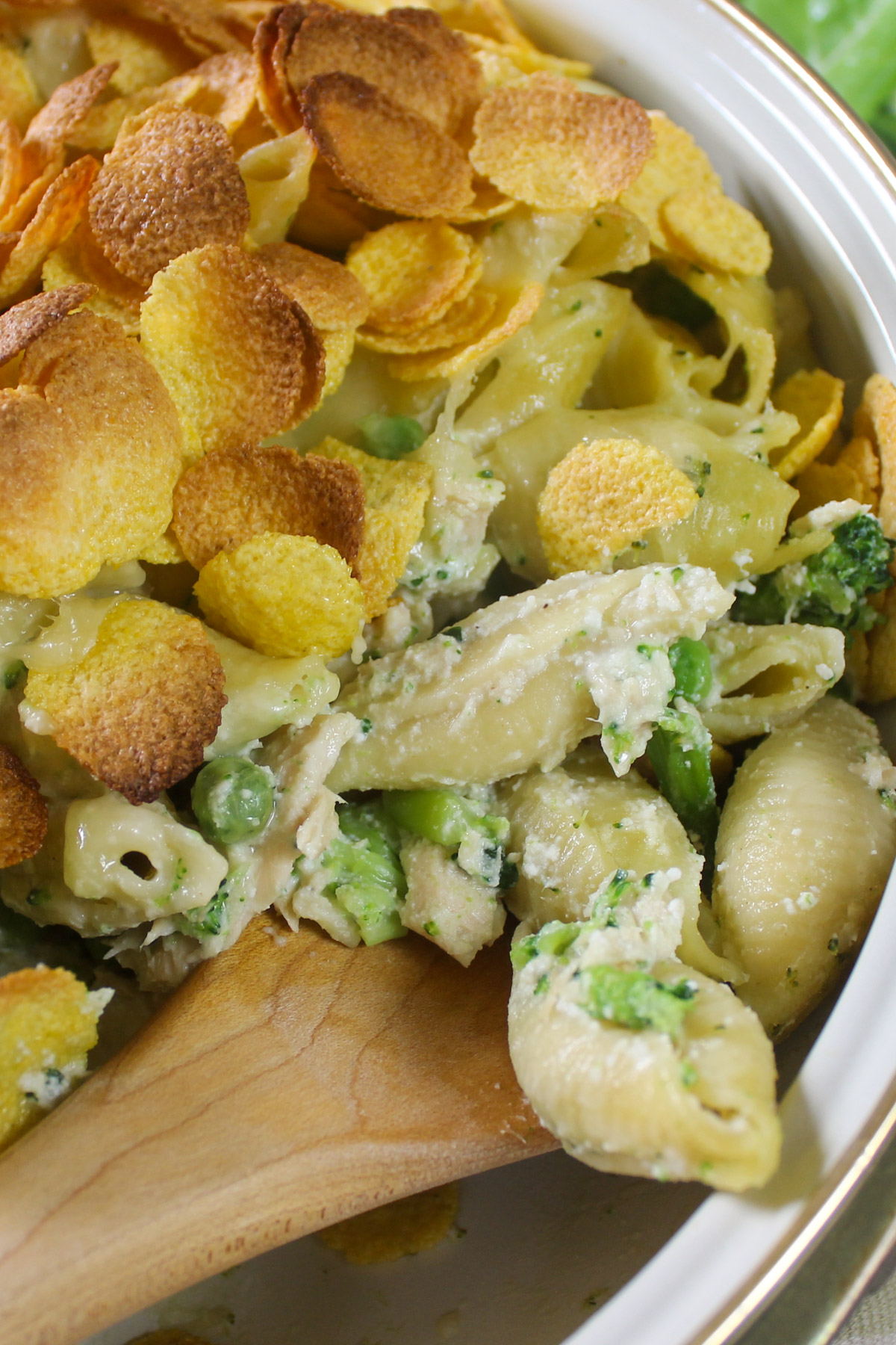 Tuna Broccoli Pasta baked being scooped with a wooden spoon.