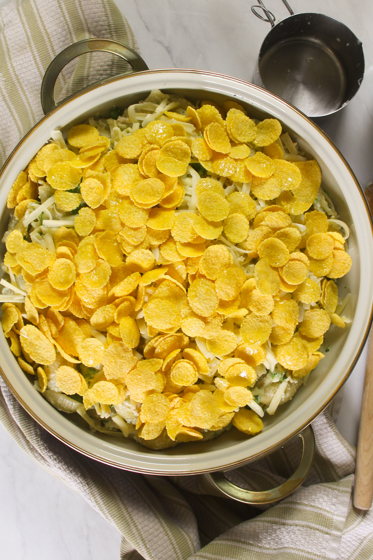 Tuna Broccoli Pasta Bake topped with cheese and buttered cornflakes, ready to bake.