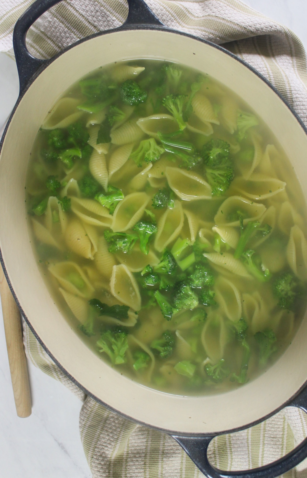 Large pasta shells and chopped broccoli boiling together to finish at the same time.