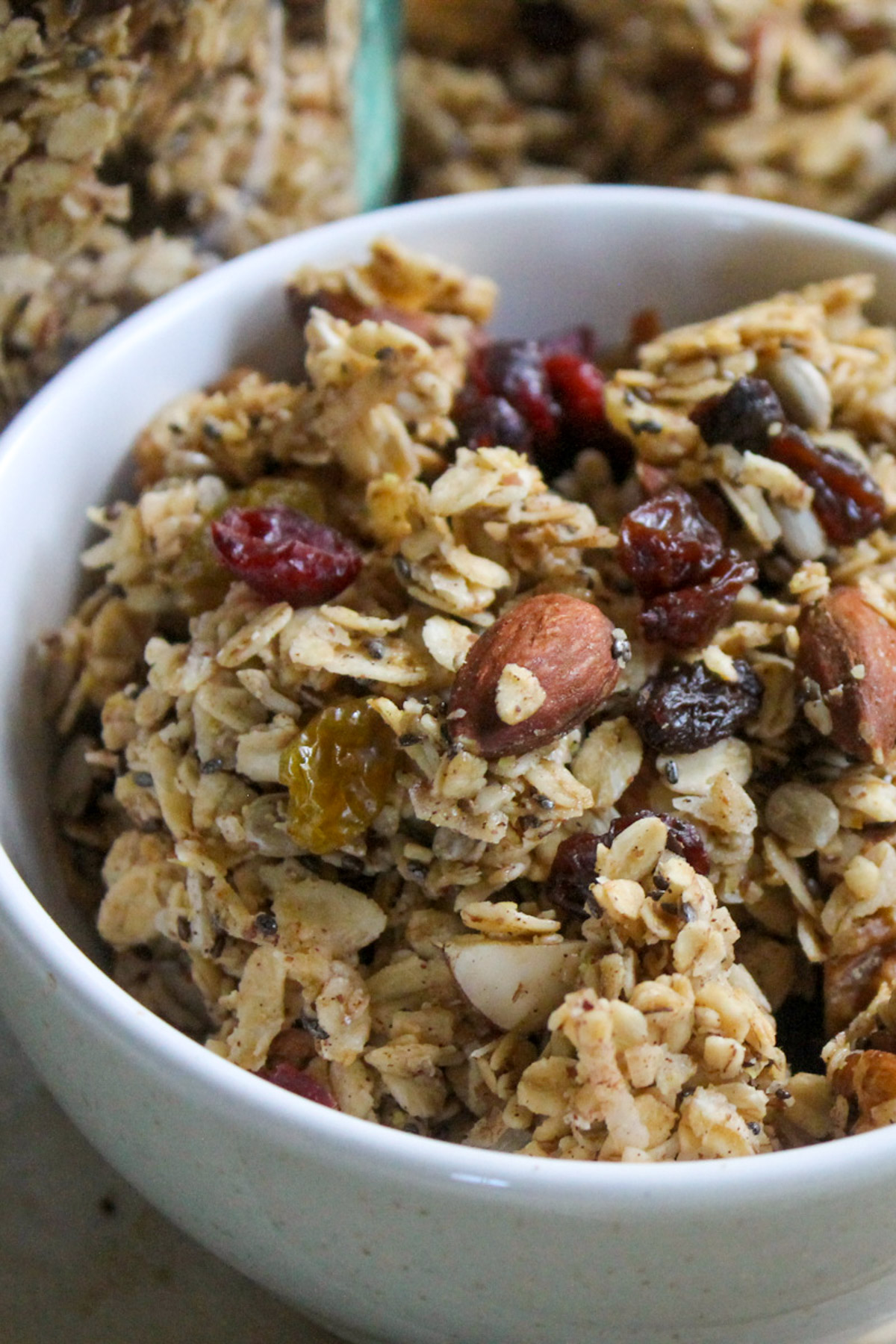 A bowl of almond spiced granola with big clusters and dried fruit.
