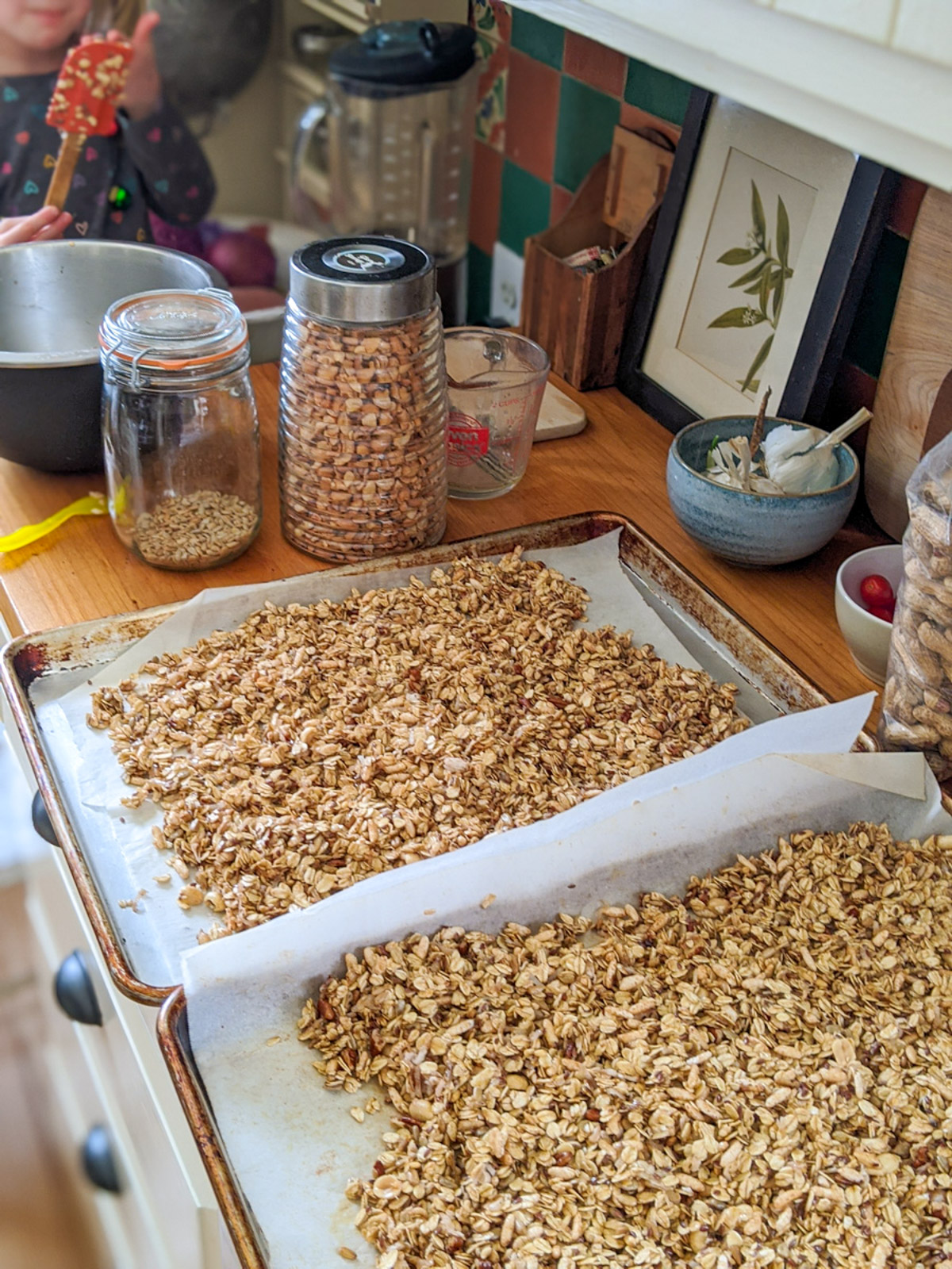 Almond Spiced Granola on sheet pans with parchment paper ready for the oven.