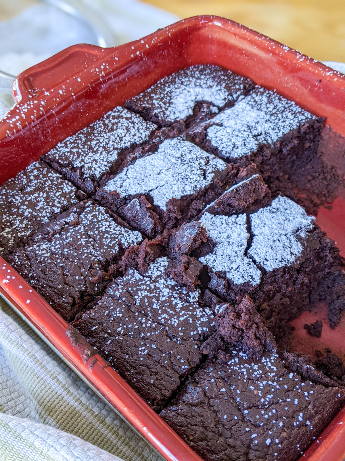 Protein brownies with black beans cut into squares in a red baking dish.