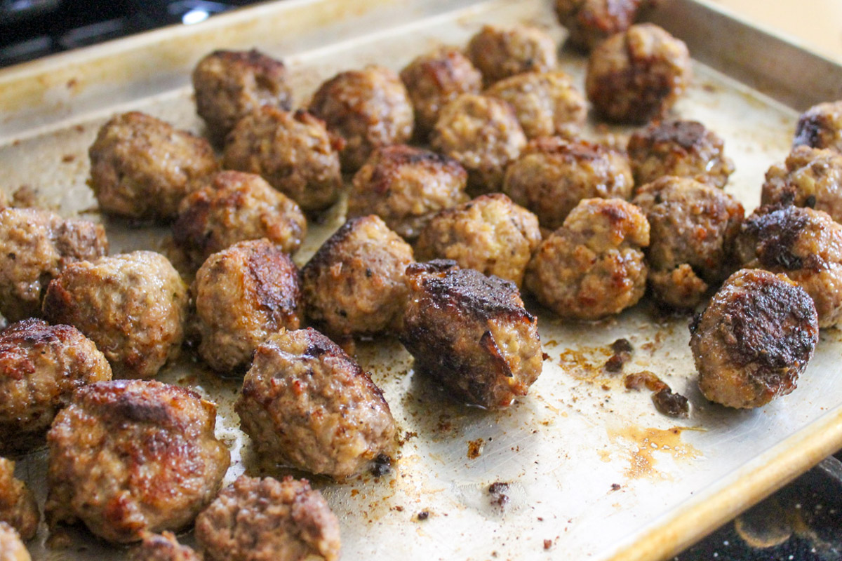 A sheet pan of meatballs baked in the oven.
