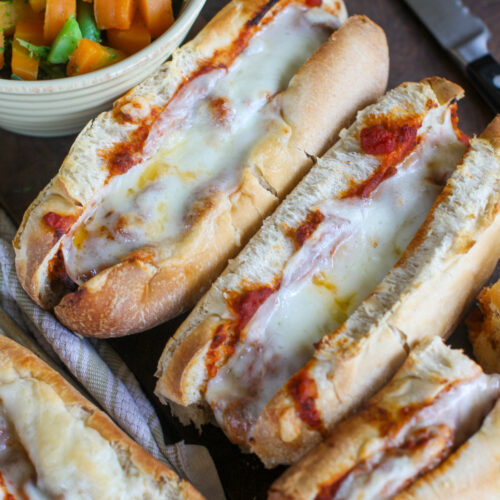 Meatball subs with marinara and white melty cheese.