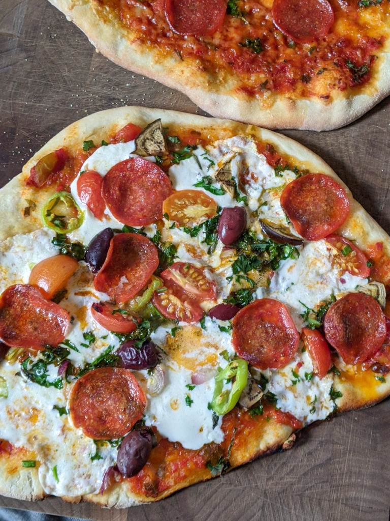 Homemade Pizza with pepperoni, peppers, mozzarella, tomato and olives