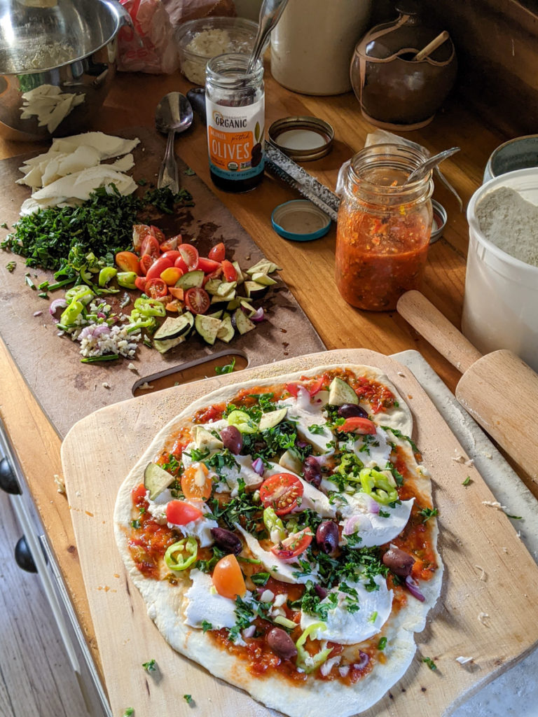 Topping pizza dough with veggies ready for the oven
