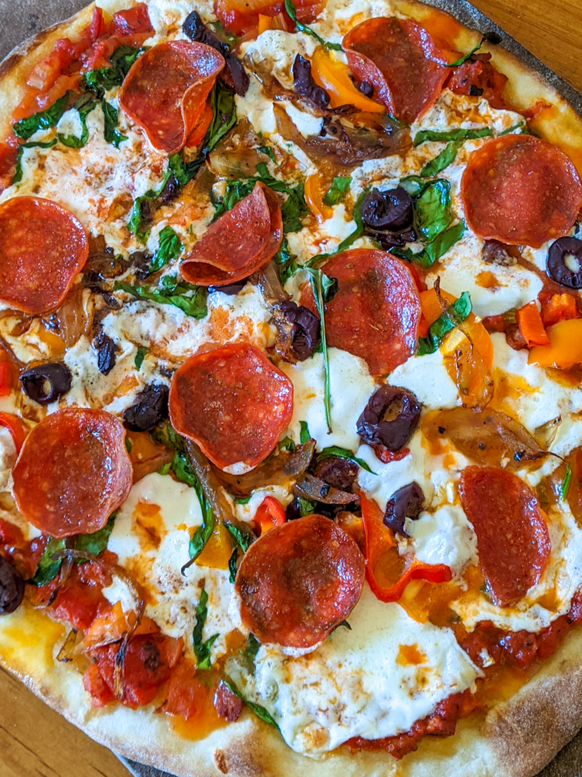 Pepperoni pizza with mozzarella cheese, olives and veggies.
