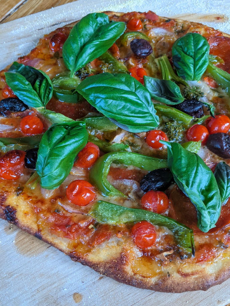 Homemade pizza with green pepper, cherry tomato and basil
