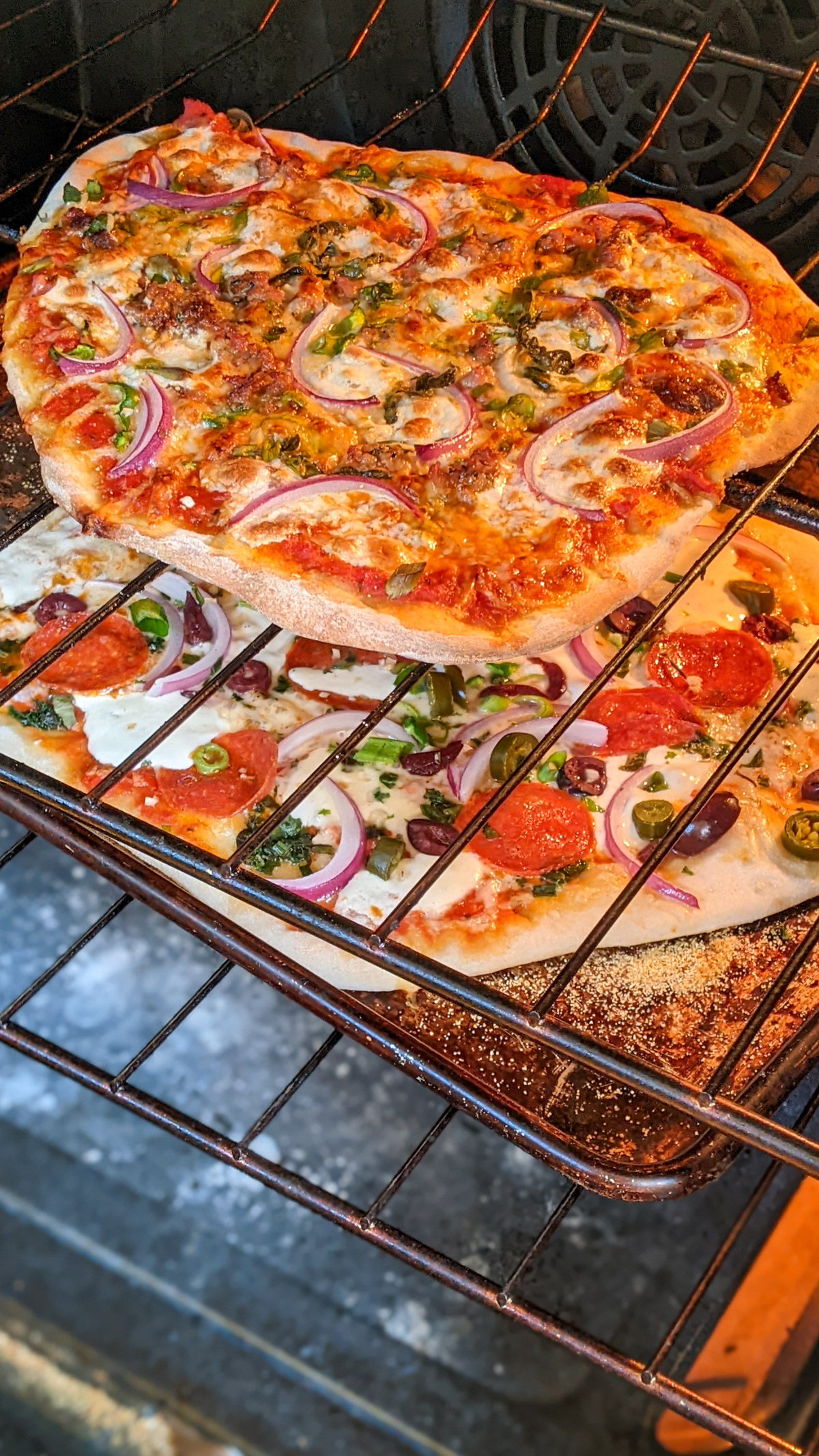 Baking 2 homemade pizzas in the oven on a sheet pan and directly on the oven rack.