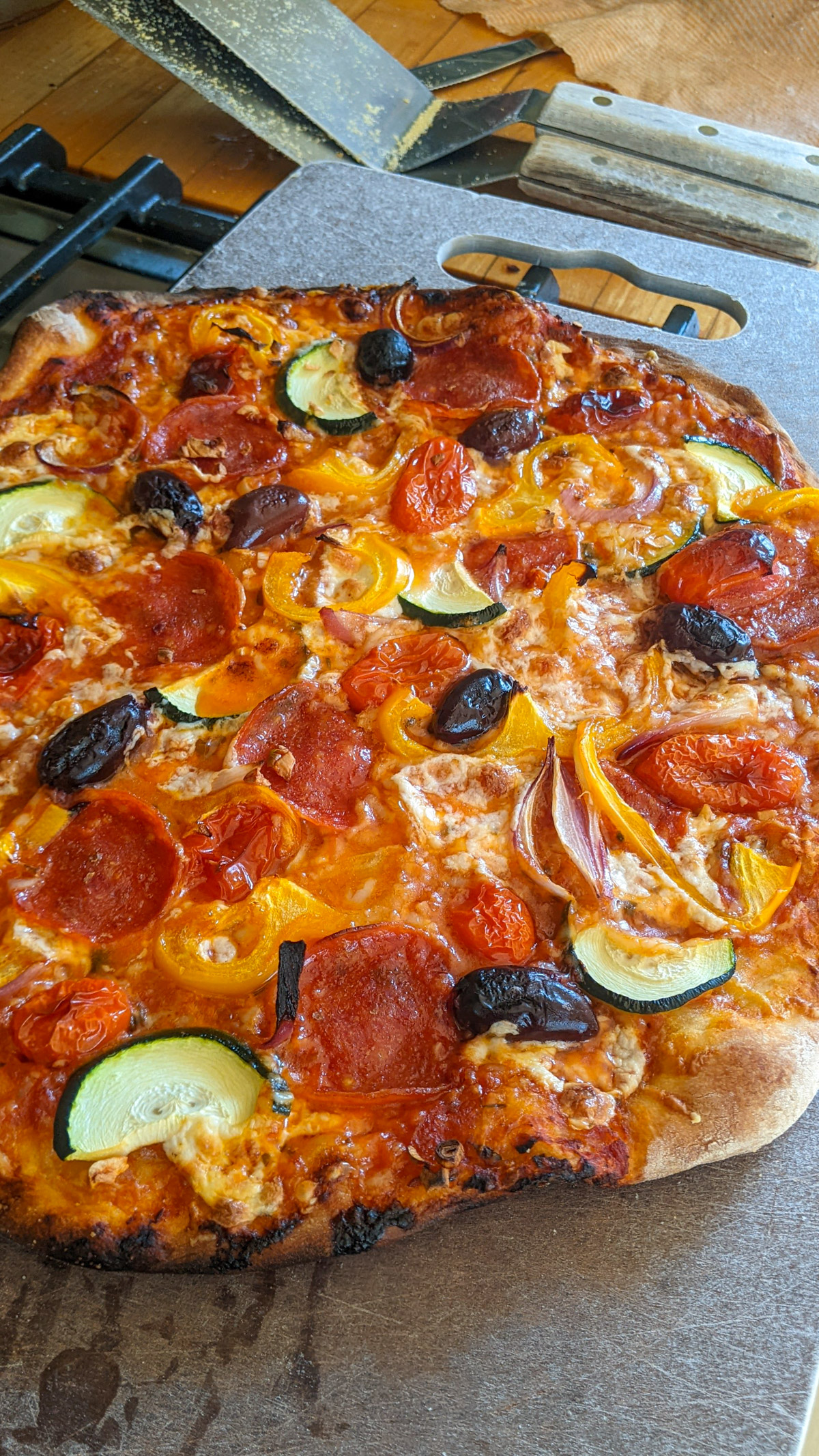 Homemade Pizza next to 2 sturdy metal spatulas for transferring pizza through the oven.