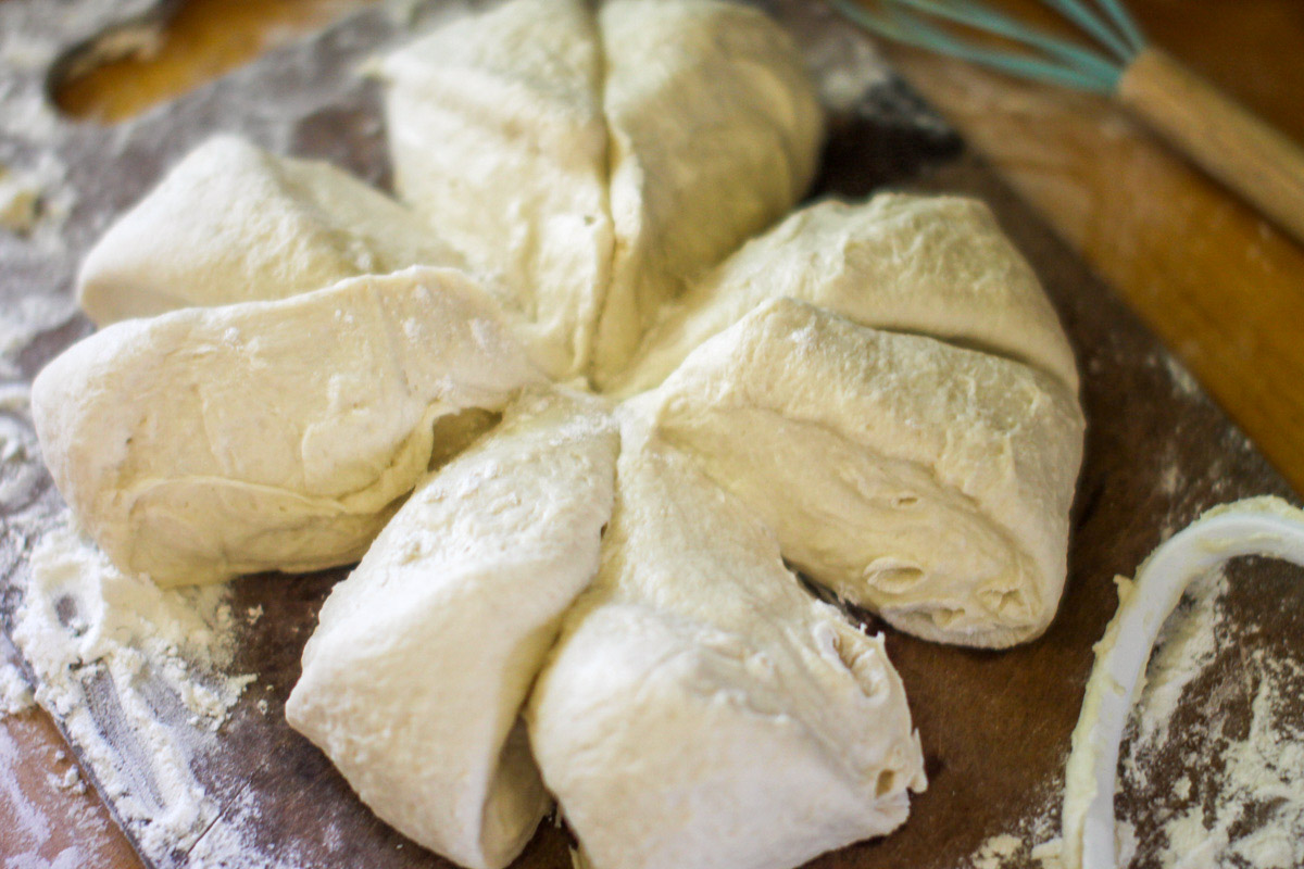 Homemade Pizza Dough being portioned into 8 pieces on a cutting board.