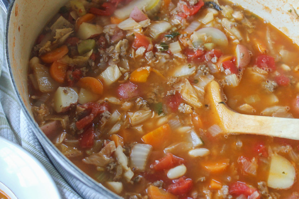 Pot of Hamburger Cabbage Soup with potatoes and beans.