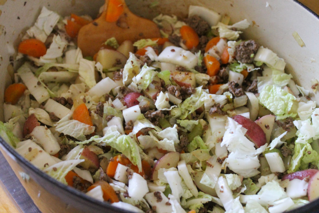 Adding sliced cabbage to the sauteeing veggies and ground beef for soup.