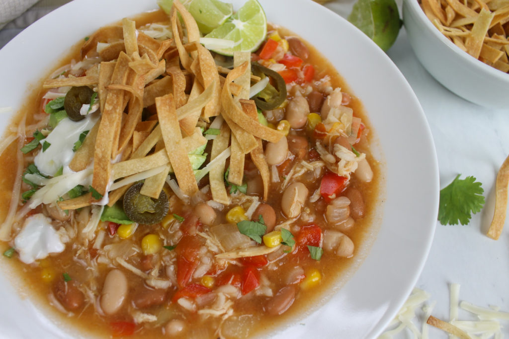 Bowl of Chicken Tortilla Soup with lots of toppings.