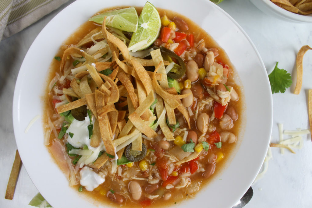 Bowl of 30 minute tortilla soup with crispy corn tortilla strips.