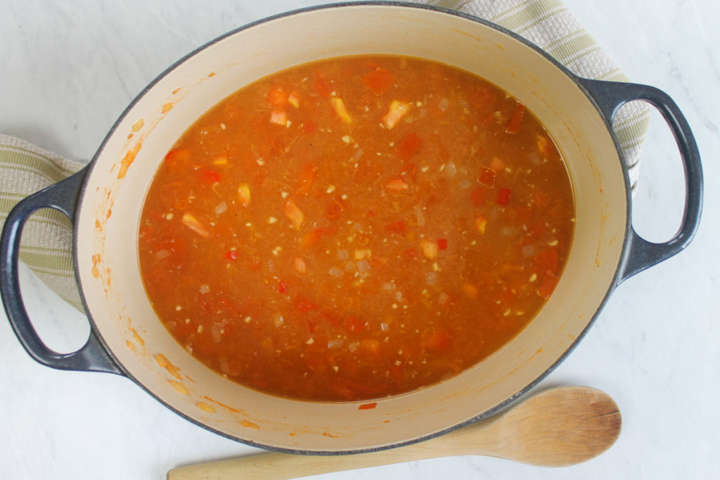 Chicken stock and rice cooking with vegetables.