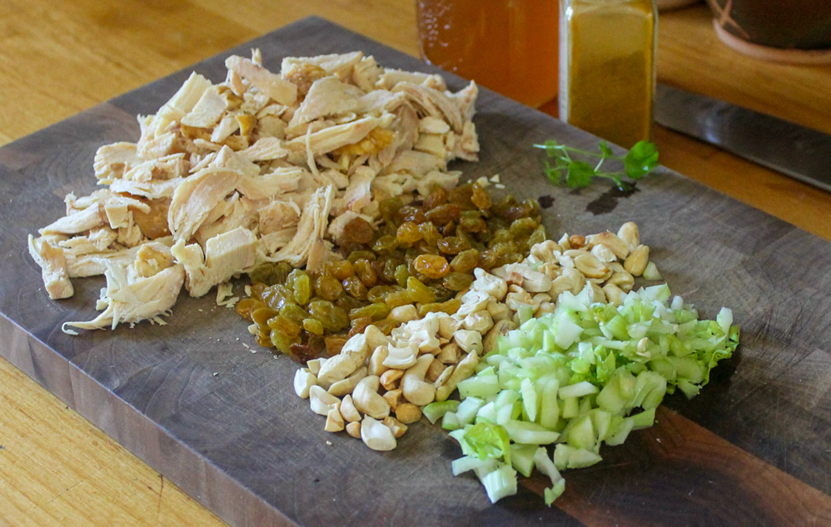 Curry Chicken Salad Ingredients chopped on a cutting board.