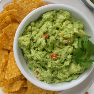 A bowl of classic guacamole with cilantro.