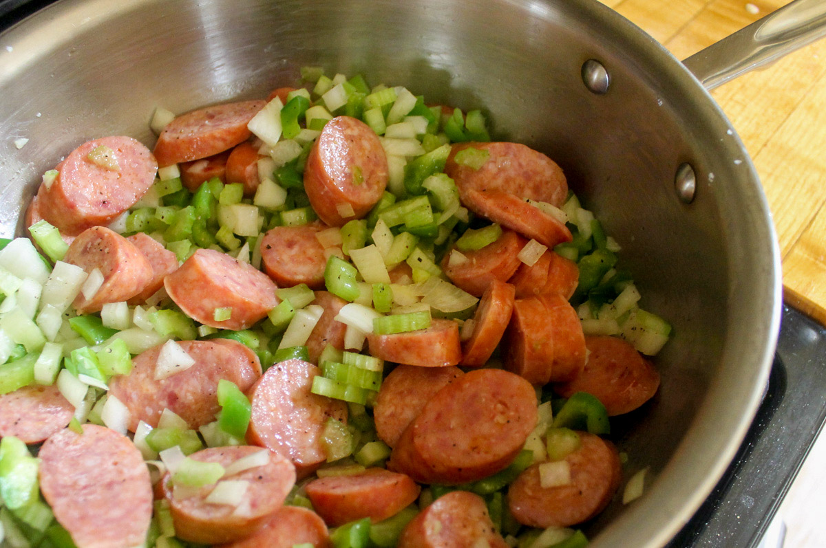 Sautéing kielbasa and veggies in a skillet for jambalaya.