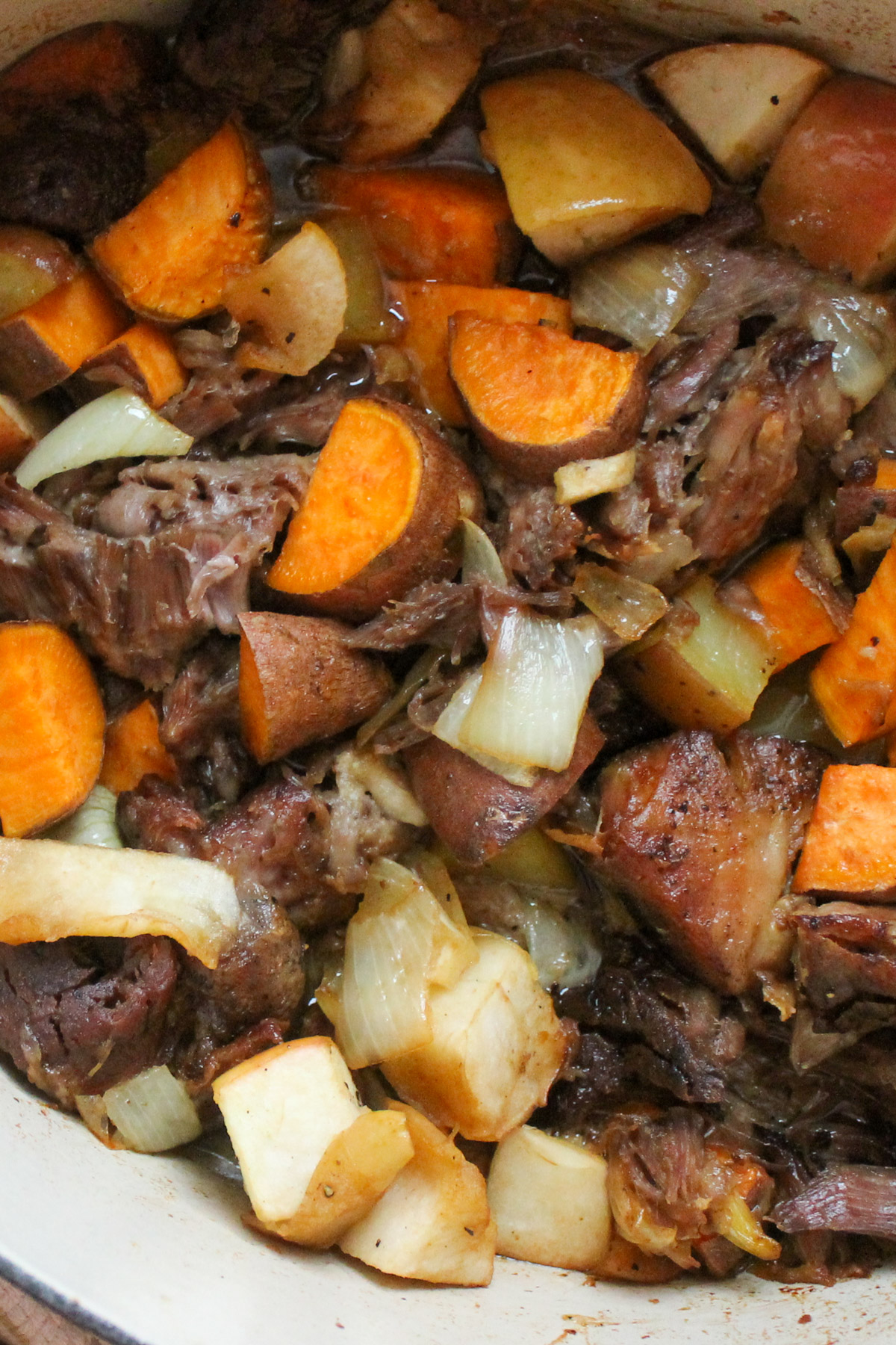 Close up of Dutch Oven One Pot Maple Pork Roast with Sweet Potato, Onion and Apple.