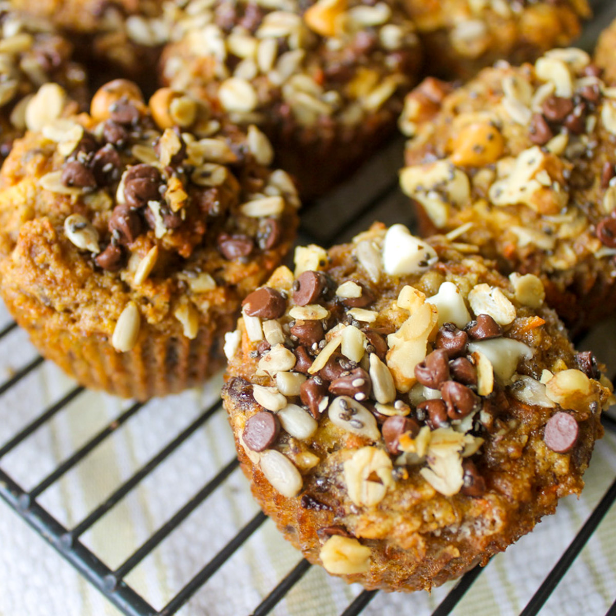 Morning Glory Carrot and Banana Muffins with lots of topping made from chocolate chips, sunflower seeds, chia seeds, walnuts, butterscotch and white chocolate chips.