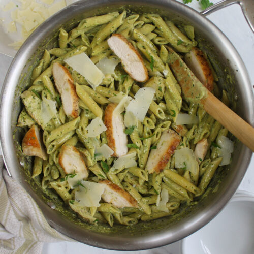 A pan of Pesto Alfredo Pasta with penne and sliced chicken.