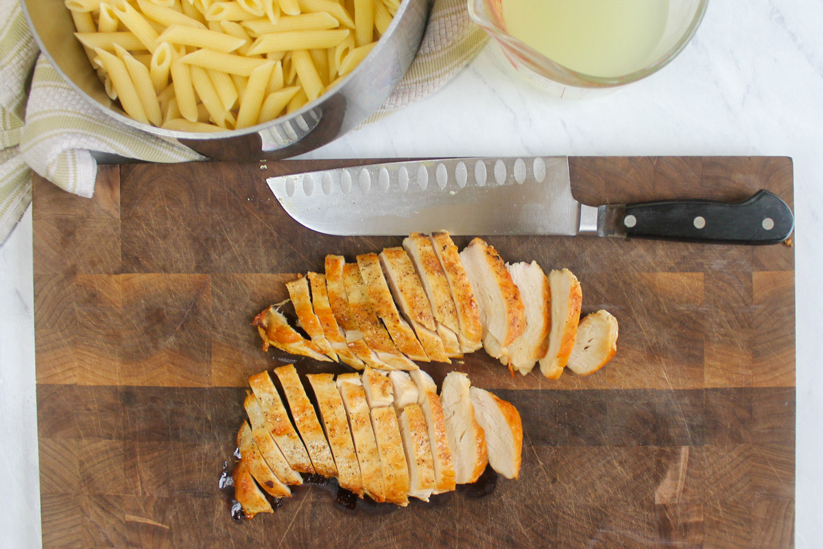 Two sliced chicken breasts on a cutting board.