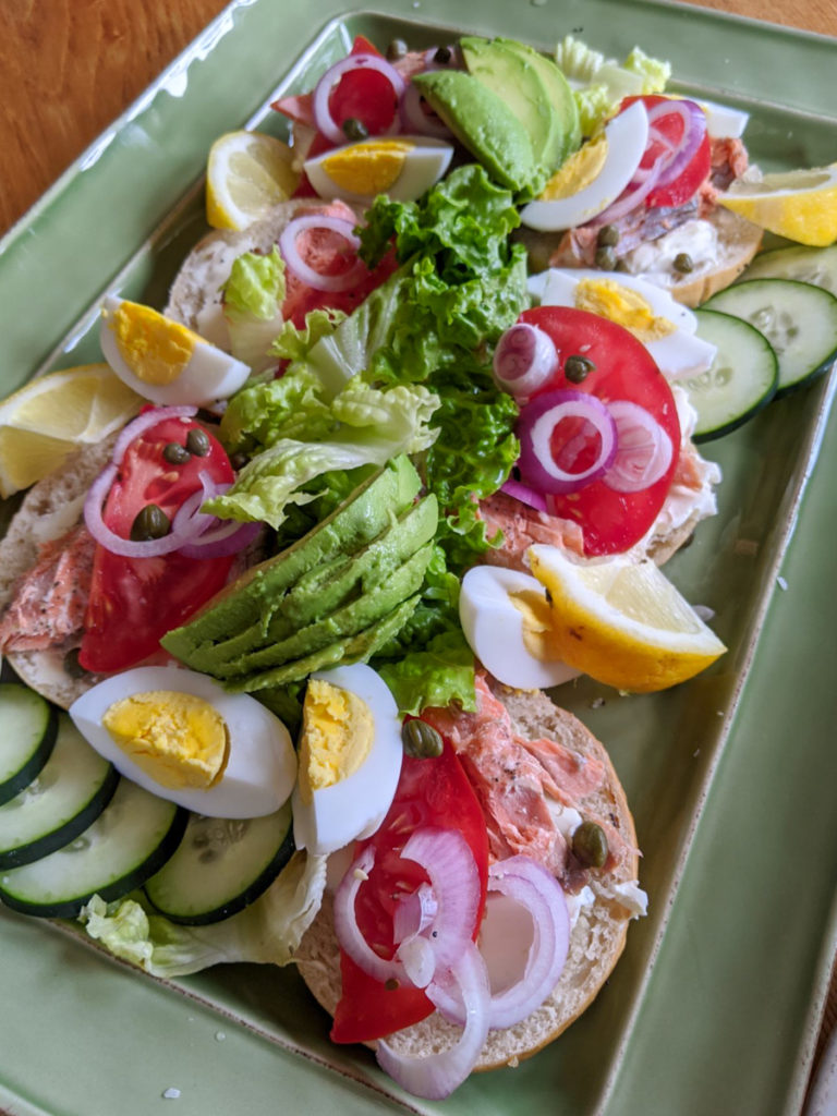 Avocado Salmon bagel platter with capers, lemon and cucumber.