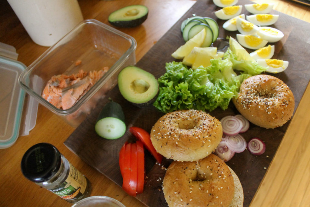 Ingredients on a cutting board for a salmon bagel platter.