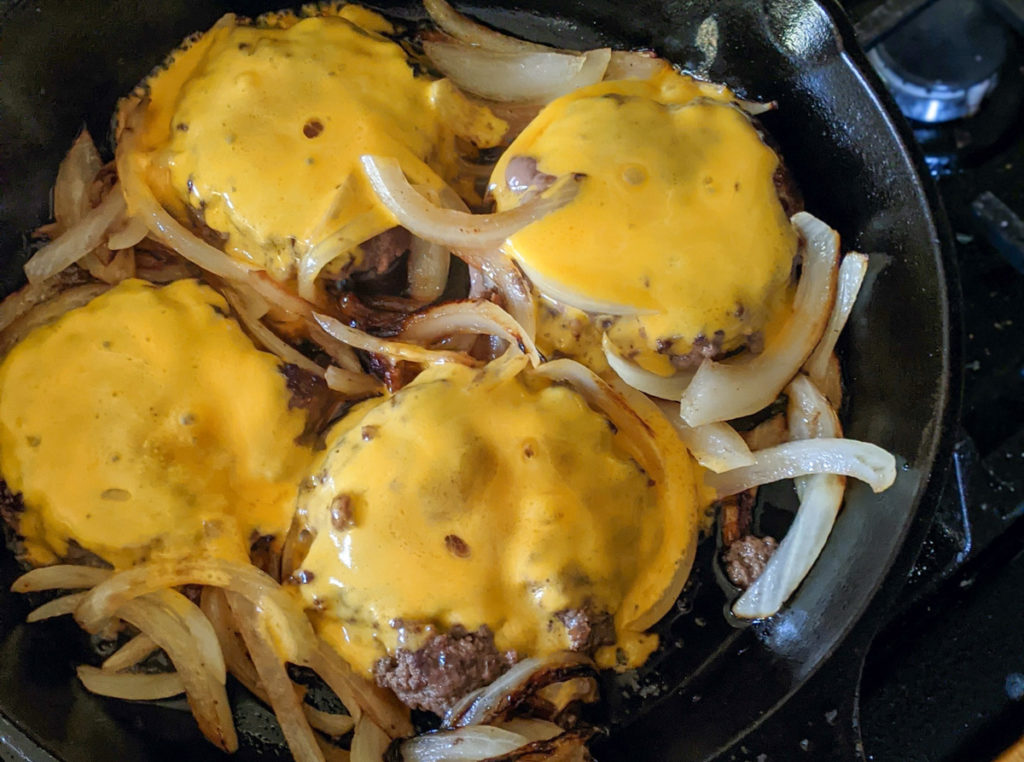 Cast Iron Skillet Burgers with melted cheese and caramelized onions